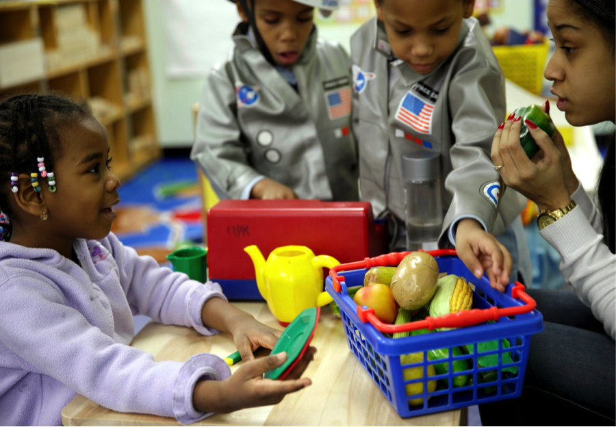 Oumou Balde, 4, with her teacher,  Jacqueline Sanchez, in a nutrition program in New York. (courtesy of Seth Wenig/Associated Press)